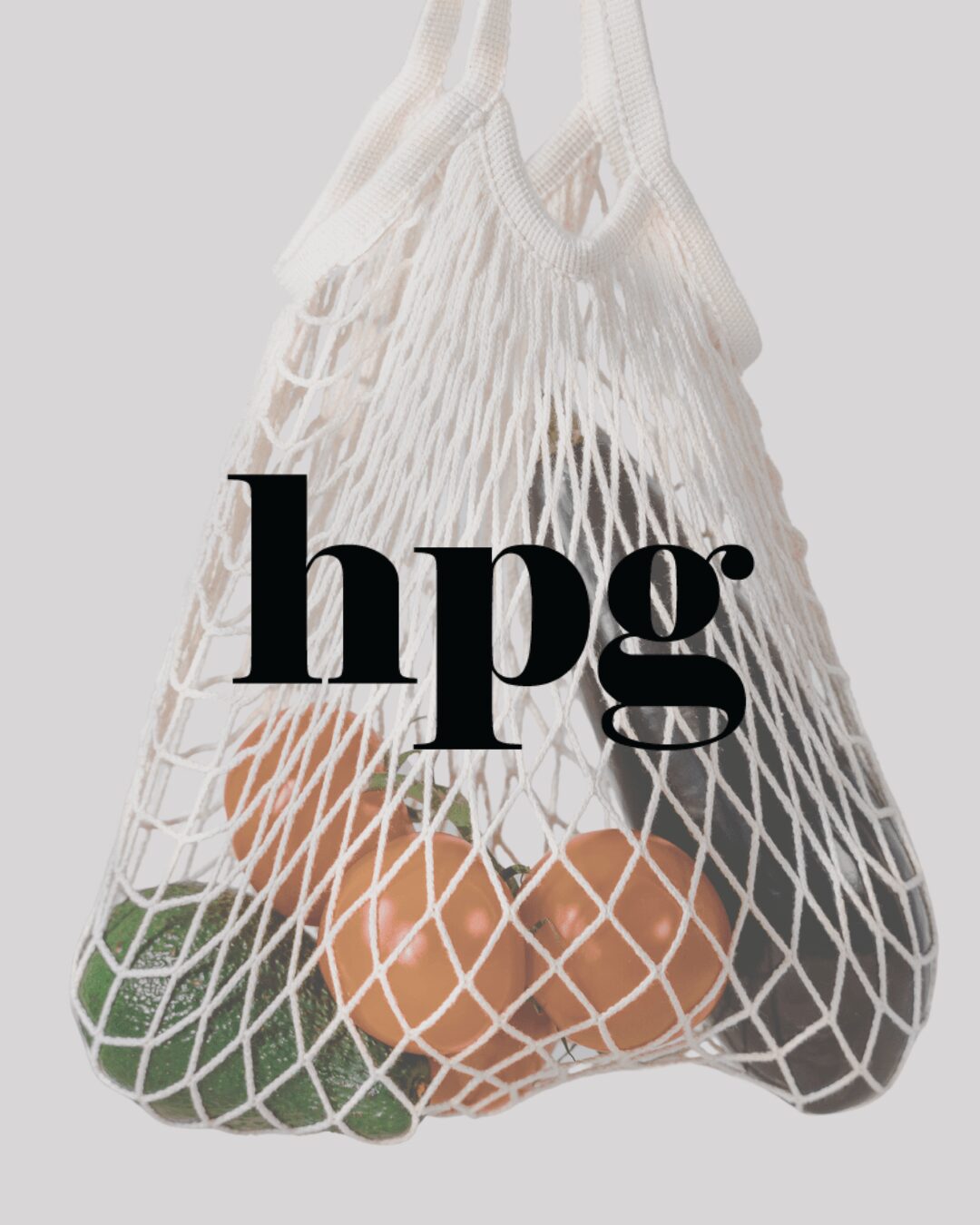 Mesh bag containing green, orange, and purple vegetables or fruits, with the text 'hpg' overlaid.