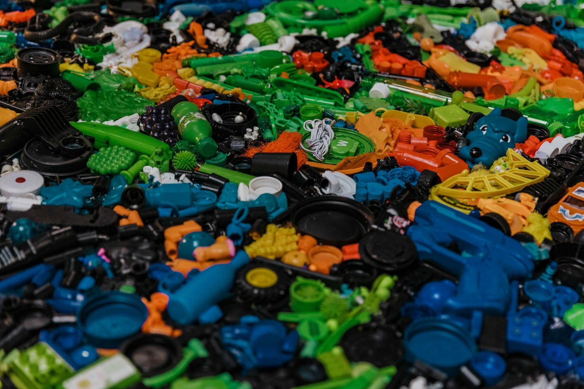 Colorful assortment of plastic toy parts, including gears, wheels, and connectors, in various colors and shapes.