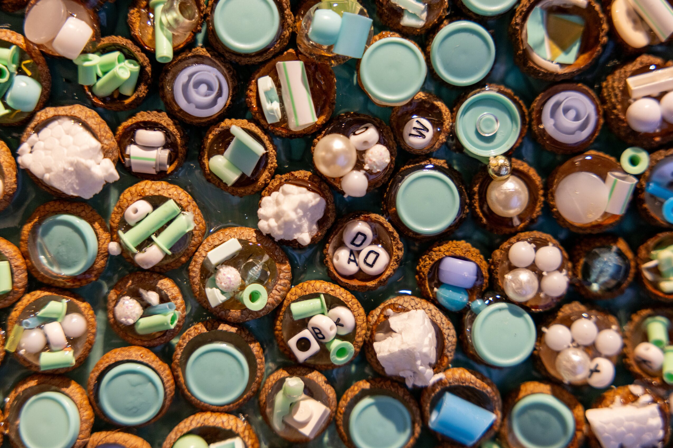 Close-up of decorated cupcakes with colorful sprinkles and toppings, densely packed together.