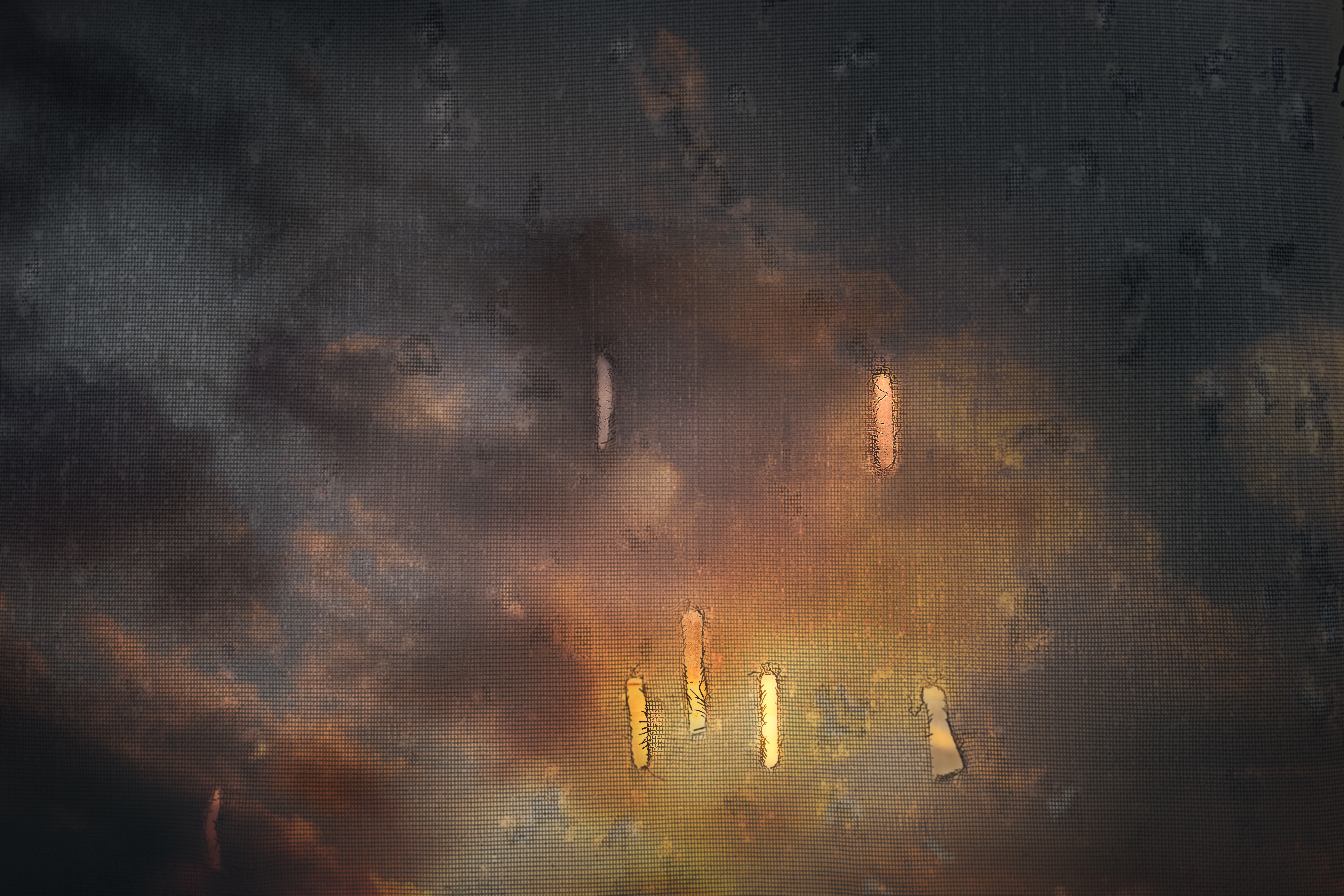 View through a rain-covered window showing blurred city lights at night.