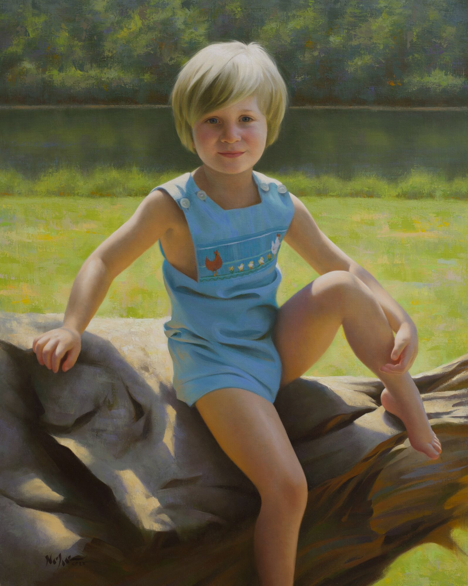 Young girl with short blonde hair sitting on a large fallen tree trunk outdoors near a lake, smiling, wearing a blue sleeveless outfit.