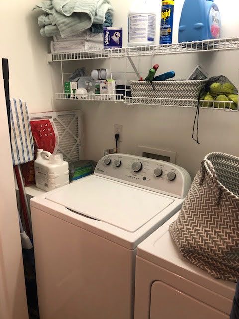Laundry room with shelves, washing machine, and various cleaning supplies and items.