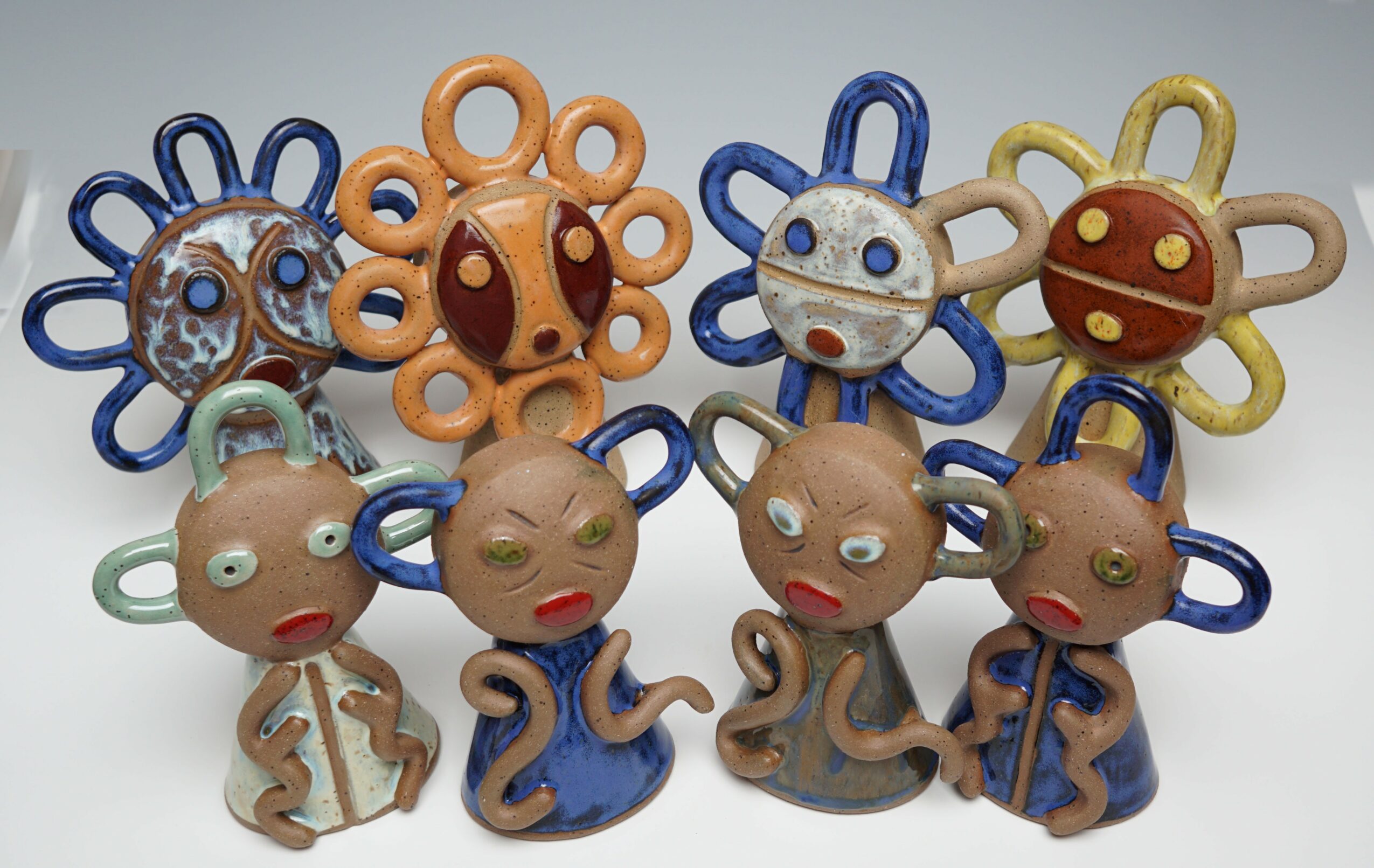 Collection of colorful, cartoonish animal and character figurines with exaggerated features and looped limbs, arranged on a white surface.