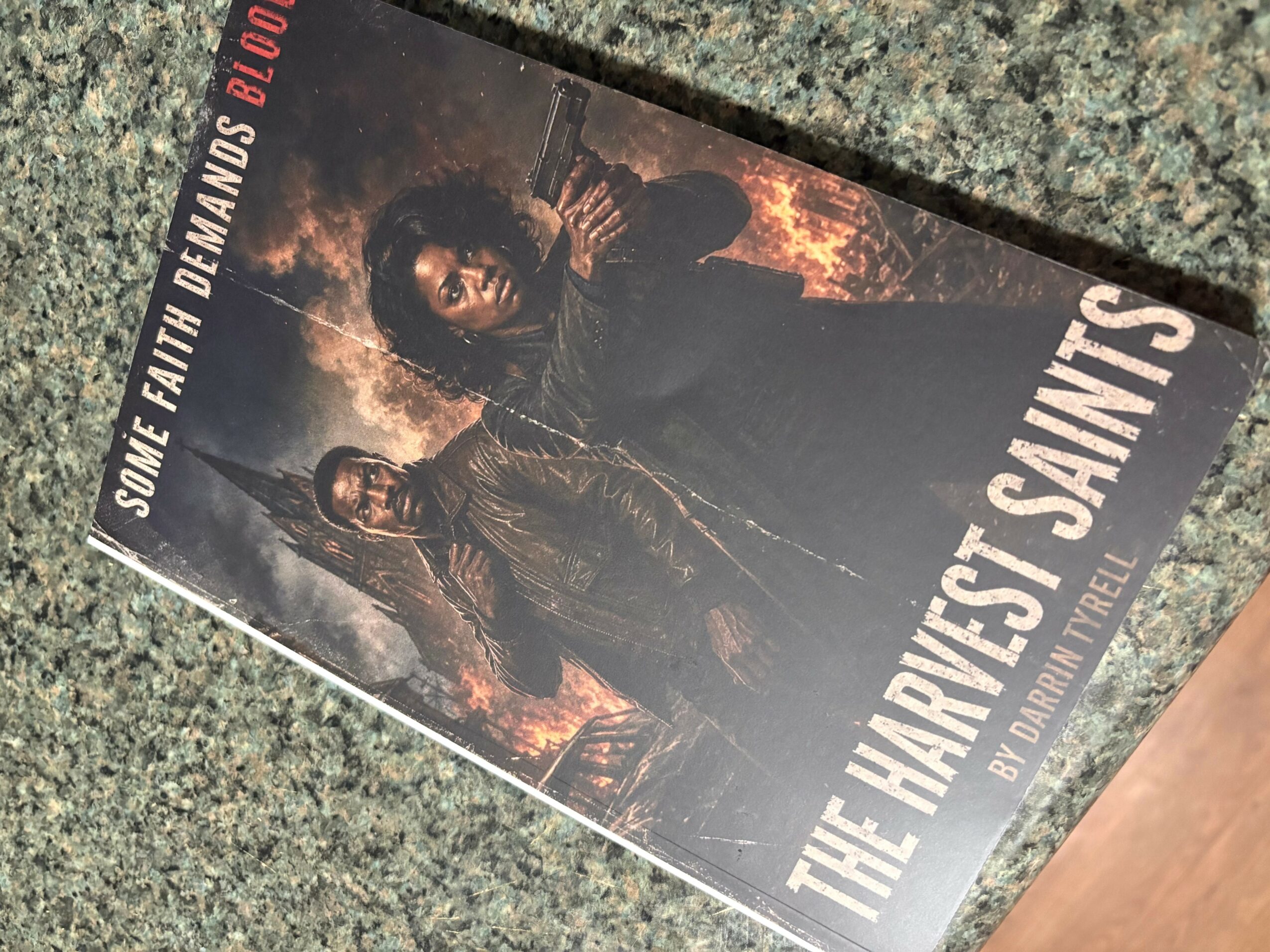 Book cover titled 'The Harvest Saints' with two characters in dark clothing against a fiery background.