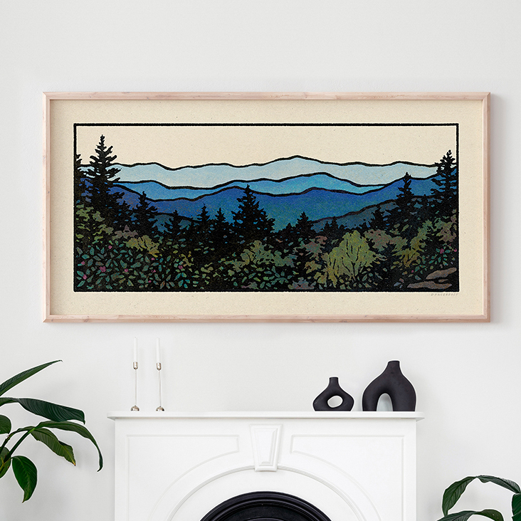 Landscape painting of layered mountains and trees in a wooden frame, hung above a white fireplace mantel, with decorative vases.