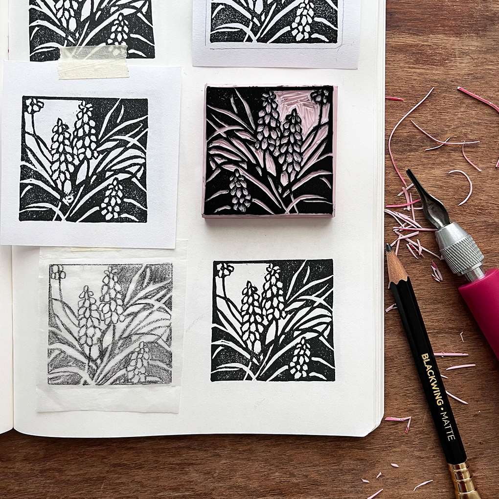 Six square stamps with floral patterns arranged on a white surface, with tools and pink thread nearby.