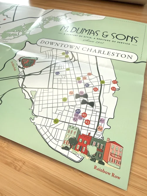 Map of downtown Charleston with colorful buildings and streets, titled 'M. Dumas & Sons' and 'Rainbow Row'.