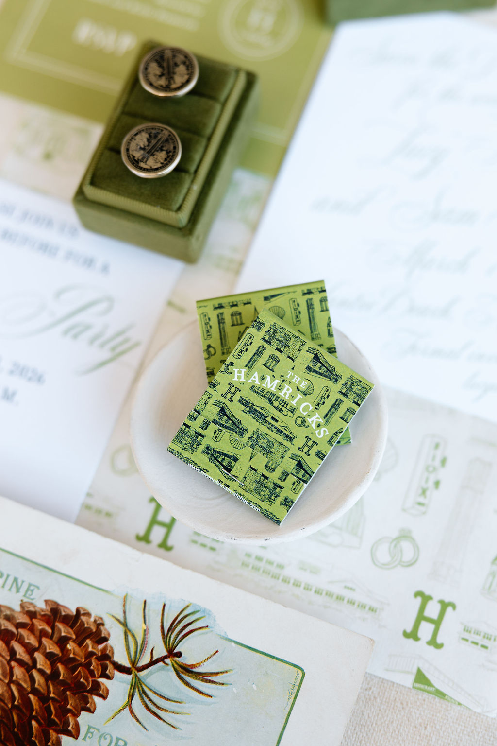 Close-up of green stamps and a small container with two stamps, on paper with printed text and illustrations.